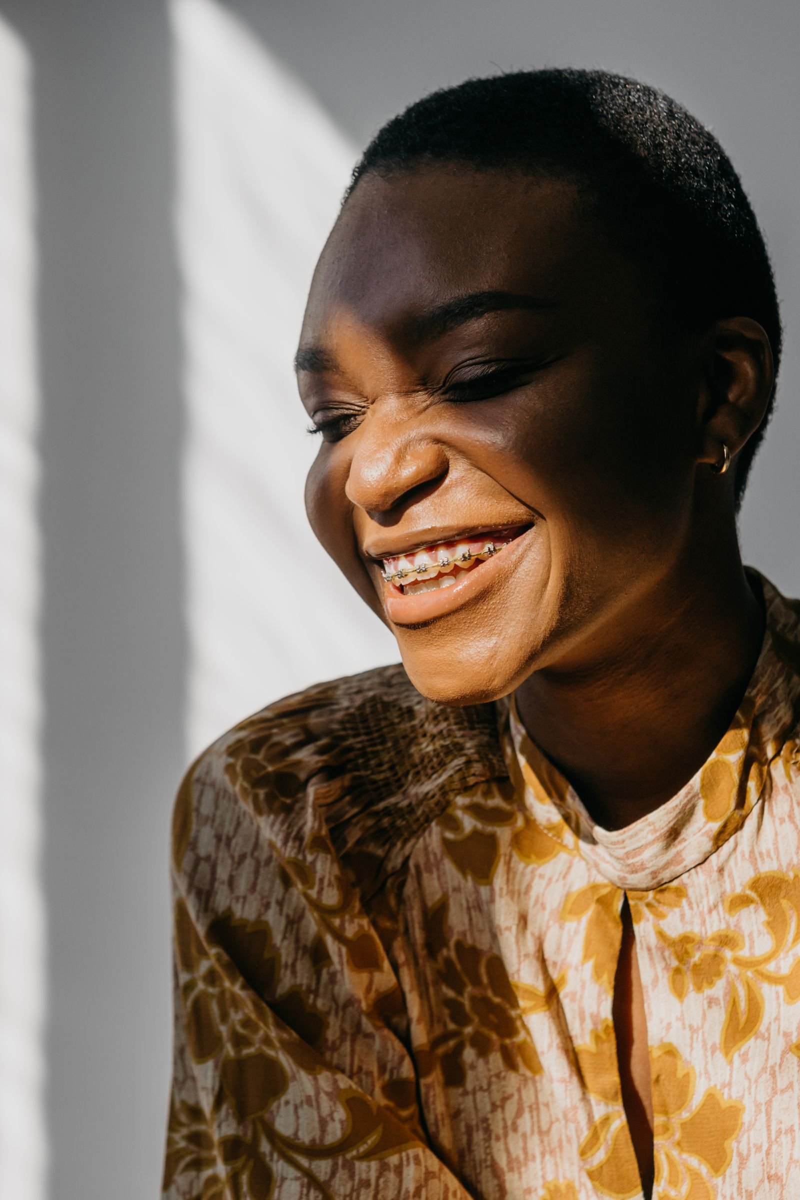 Illustrative photograph of an adult smiling with braces